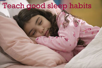 Young girl sleeping in bed with the text "Teach good sleep habits" over the photo.